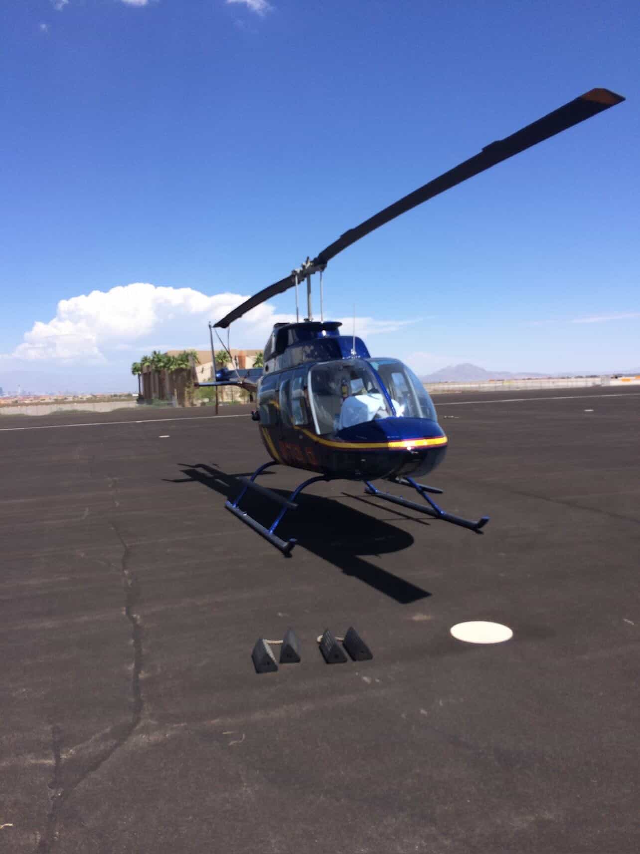Dark blue Bell 206 on dedicated charter pad